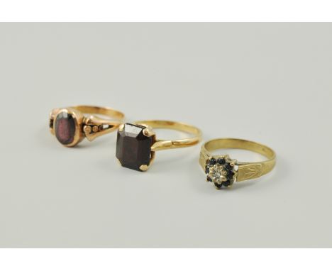 9ct sapphire and diamond cluster ring, together with two yellow metal garnet set single stone rings, (3).