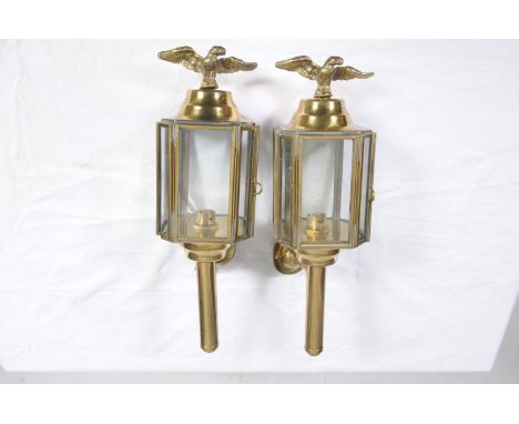 A pair of vintage brass trap lamps, early 20th CenturyEach applied with an eagle finial above the four panel glass lamps, lat