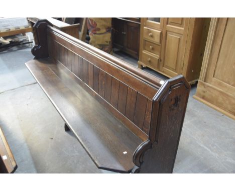 A Victorian oak church pewThe rectangular seats with canted front corners raised on shaped bracket type supports and fitted w