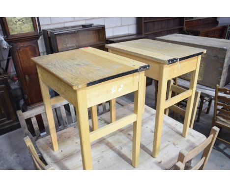 A pair of vintage ash school desksEach with a hinged top raised upon legs of chamfered  square section, 62cm wide. 