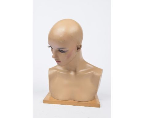 A vintage shop mannequin bustWith applied eyelashes and makeup raised on a wooden plinth base, 43cm high. 