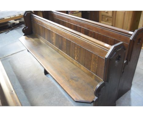 A Victorian oak church pewThe rectangular seats with canted front corners raised on shaped bracket type supports and fitted w