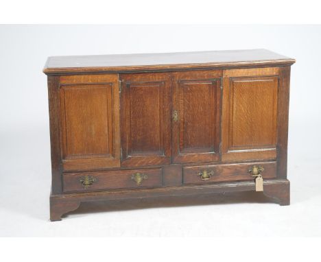 A late 18th Century oak mule chestLater converted, the fixed rectangular molded top above a pair of fielded paneled cupboard 
