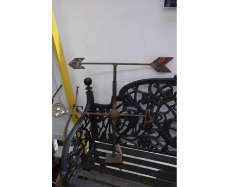 An iron work weather vaneThe arrow shaped pointer mounted within a tubular frame above 'N' and 'S' markers. 