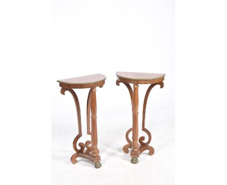 A pair of mahogany half moon lamp tables, 20th CenturyThe half moon table tops with a gilt metal border raised on a front rin