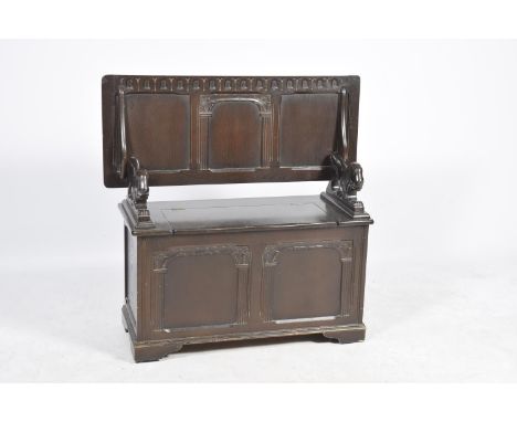 A mid 20th Century oak Monks benchThe folding three panel top supported on lion figural brackets above a box section and two 