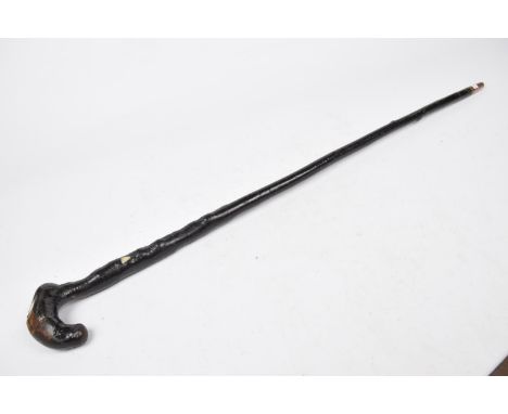 A vintage carved hardwood walking stickThe gnarled stick with curved handle inset with plied compass, overall stained and pat