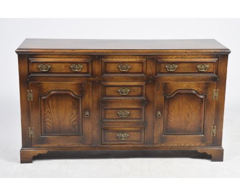 A lovely quality George III style oak dresser base, 20th CenturyThe rectangular moulded crossbanded top above an arrangement 