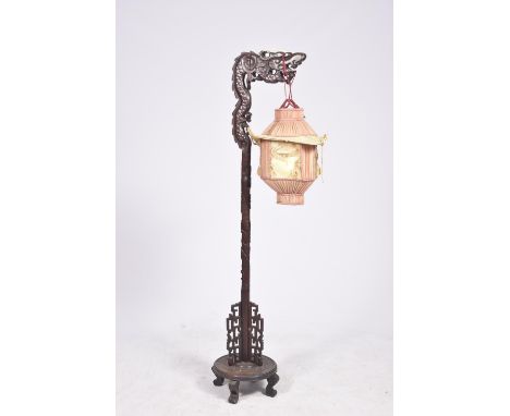 A Chinese carved hard wood stand lamp, circa 1930 The hard wood frame extending to a dragon formed terminal, and rising from 