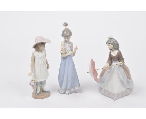 A group of three Lladro and Nao figures To include two young girls with umbrella's and another holding a bouquet of flowers, 