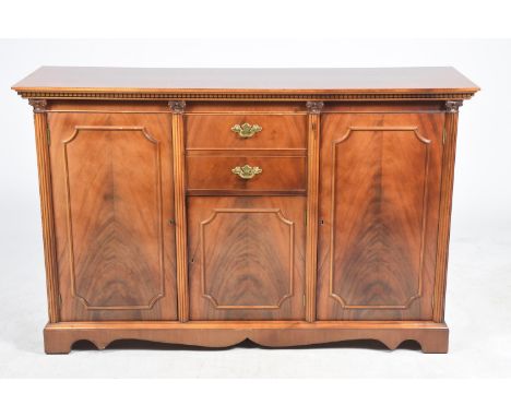 A reproduction mahogany Regency style sideboardHaving a rectangular top above two central drawers and a central cupboard door