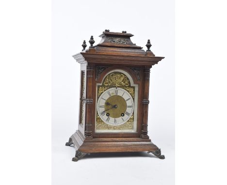 An early 20th Century  Lenzkirch German mantle clockThe oak architectural casing raised on a stepped base with exterior calve