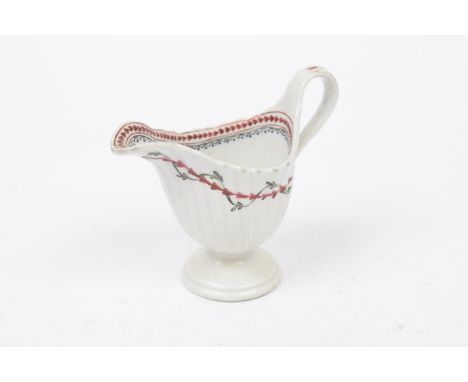 A New Hall porcelain pedestal cream jug, circa 1780Of helmet form raised on a pedestal splayed base with high loop handle, th
