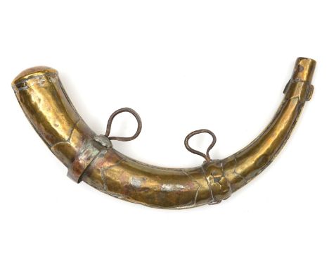 A Moroccan brass powder flask of horn shape. Possibly late 19th century, 28cms, front with pierced brass decoration engraved 