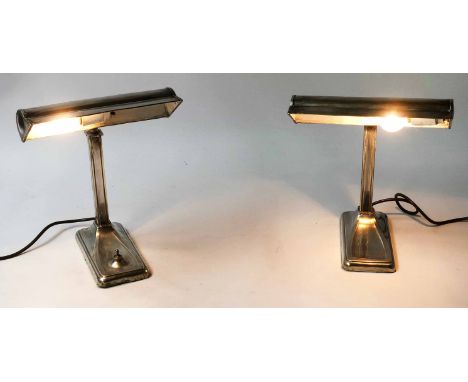 DESK LAMPS, a pair, early 20th century silvered metal, each with facetted column and hooded shade (one lamp with integral swi