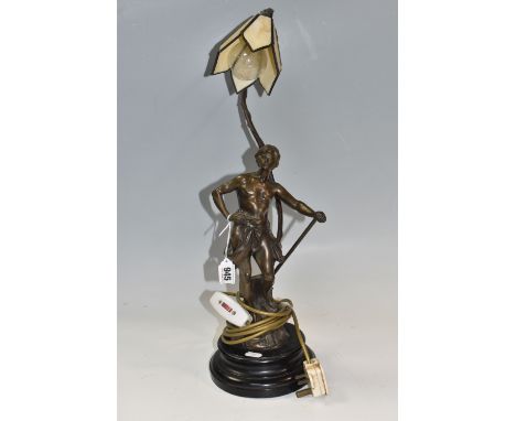 A BRONZED METAL FIGURAL TABLE LAMP, with a leaded glass shade on the form of a flower head, a figure of a young man during ha