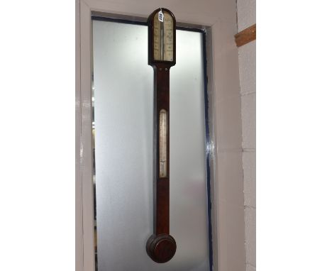 A GEORGIAN CISTERN BAROMETER, in flame cut mahogany, the arched glass door enclosing a face signed 'West, London', with integ