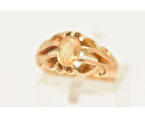 A YELLOW METAL CITRINE SET RING, set with an oval cut Citrine, claw set to the scrolling openwork shoulders and polished band