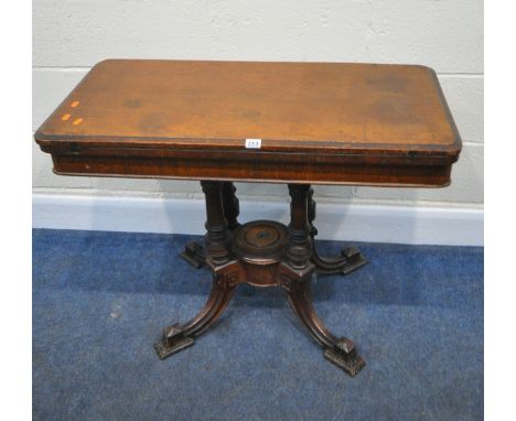 AN EDWARDIAN OAK FOLD OVER CARD / GAMES TABLE, the swivel top opens to reveal a green baize playing surface, raised on turned