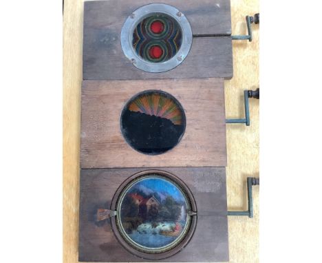 Three Victorian mechanical mahogany and glass lantern slides and a collection 19th/20th century glass lantern slides