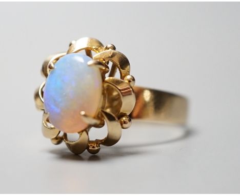 A 14k yellow metal and white opal set oval dress ring, size O, gross weight 3.9 grams.