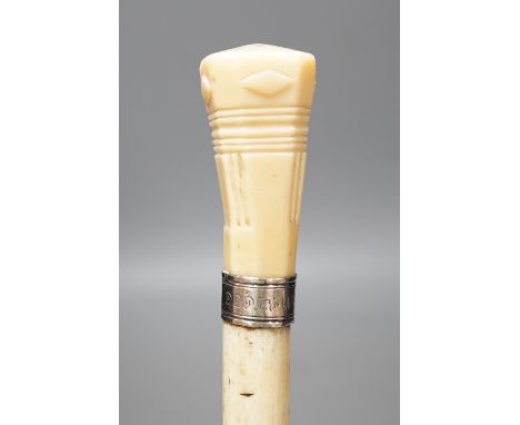 A whale bone walking stick with a whale tooth carved handle, with silver mount, 19th century