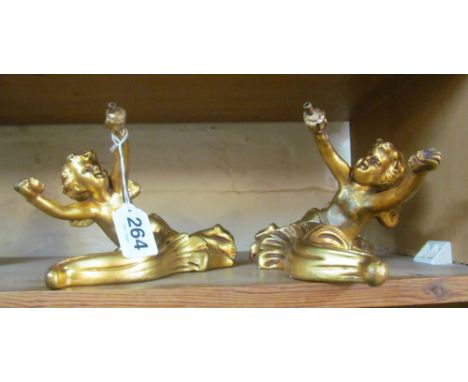 A pair of gilt cherub wall ornaments and a gilt cherub lamp