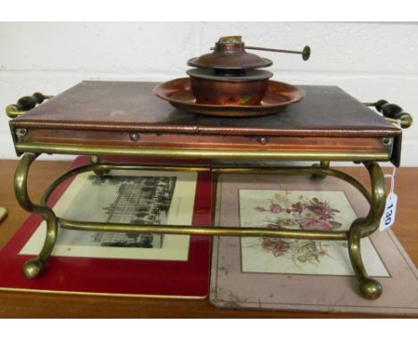 A brass finish oil lamp with glass shade and a copper and brass warming plate