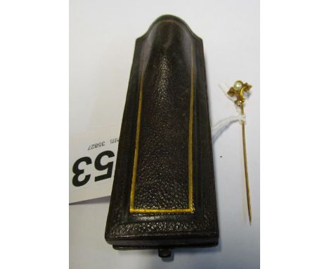 A gold coloured pearl and diamond stick pin marked 14k