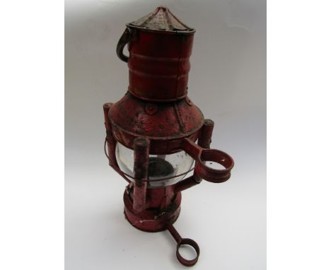 A red painted nautical signal lamp with bulbous shade