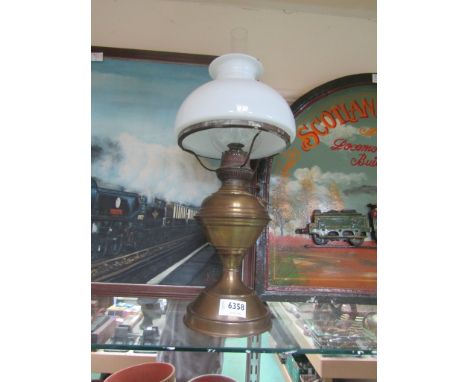 A brass oil lamp with milk glass shade chimney