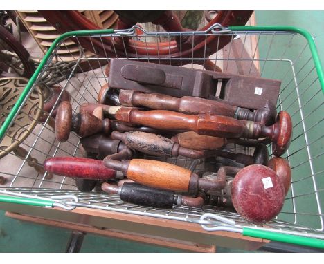 A metal basket containing vintage hand drills and braces etc 