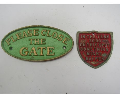 Two cast iron signs, 'Please Close the Gate' and 'In the Year 2000 On This Spot Something Might happen'