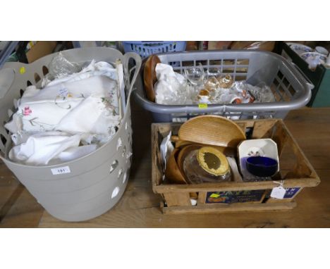 Two laundry hampers containing vintage table linens, glassware, and vintage wooden hamper with ceramics and wooden ware