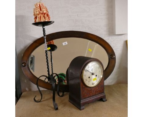 Oval oak framed mirror, wrought metal candle holder and mantel clock