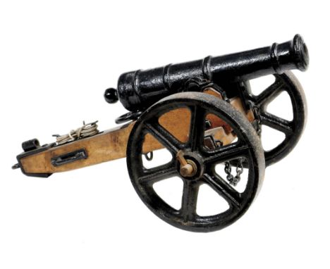 A good model cannon, iron barrel 23 in., mounted on an oak carriage with spoked cast iron wheels, iron fittings including ele