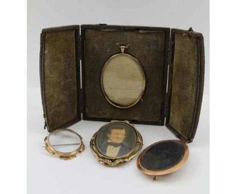 A 9CT GOLD OVAL MINIATURE FRAME in leather covered outer case, two 9ct gold brooch mounted miniature frames, and a photograph