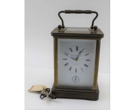 A "MATTHEW NORMAN" BRASS FRAMED CARRIAGE CLOCK, white enamel dial with Roman numerals and secondary dial, striking on gong, w