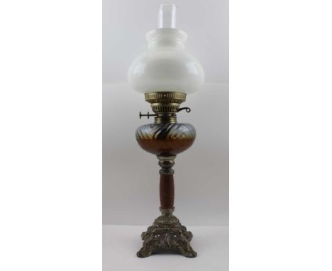 AN EDWARDIAN OIL LAMP, decoratively cast spelter base with stone column, clear wrythen glass reservoir, opaque glass shade, c