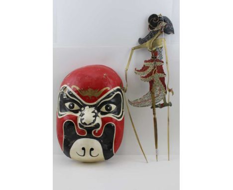 AN EARLY 20TH CENTURY INDONESIAN SHADOW PUPPET, gilded and painted with articulated arms and turned horn handles, together wi