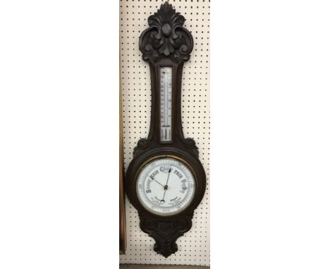 A circa 1900 carved oak cased barometer thermometer with mercury thermometer over a circular dial, 90 cm high x 29 cm wide 