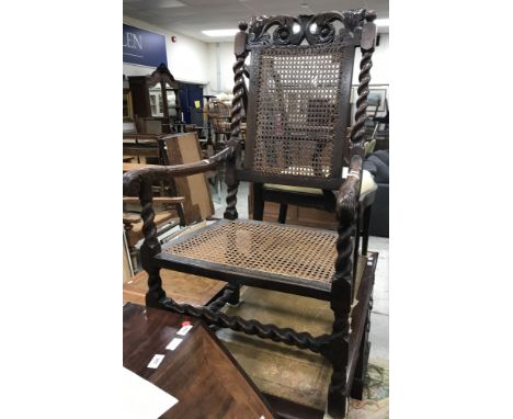 An 18th Century Flemish walnut framed hall chair with floral and foliate carved top rail above a caned back panel on barley t