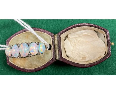 An 18 carat gold and opal ring in the Victorian taste with five graduating opals interspersed by diamond chips with scrolling