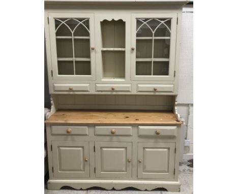 A modern painted and pine dresser, the top with two glazed doors flanking an open shelf section, over three short drawers on 