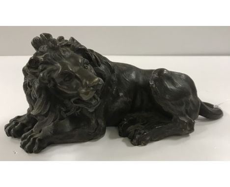 A 19th Century Continental patinated bronze figure of a "Recumbent male lion in snarling pose", 25 cm long x 11.5 cm high