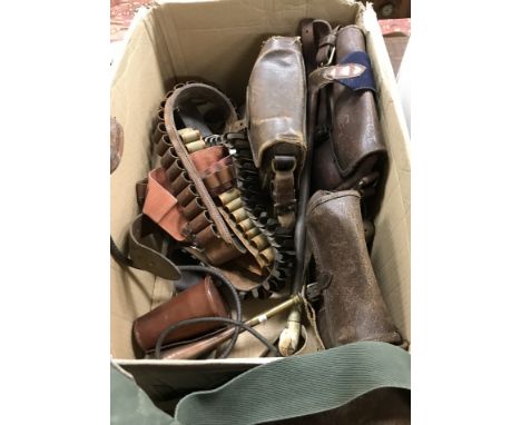 A box containing various shooting and sporting ephemera including three vintage leather cartridge bags, leather gun sleeve, N