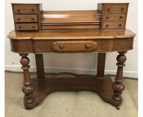 A Victorian mahogany duchess dressing table, the super structure with central lidded compartment flanked by two banks of thre