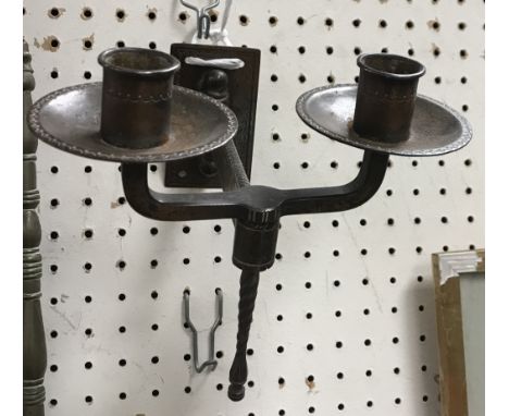 A pair of Arts and Crafts coppered twin light adjustable wall sconces, the twin candle lights with dot and wavy line decorate