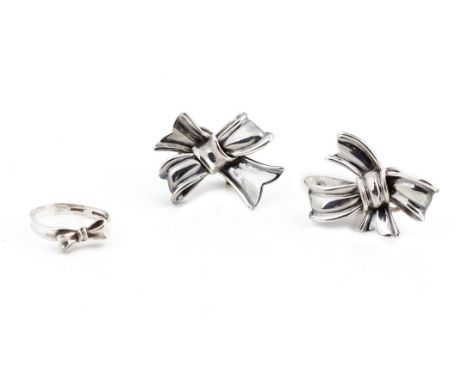 A PAIR OF ANGELA CUMMINGS SILVER CLIP ON EARRINGS AND RING
Designed as bows, marked with makers name and 'sterling', both wit