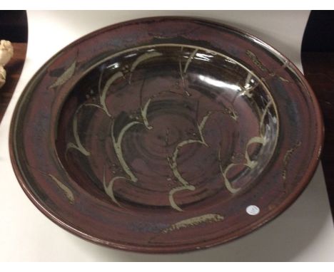 DAVID LEACH (British: 1911 - 2005): An oversized stoneware pottery centrepiece charger of 'Wave' design in deep red and black